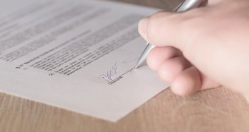 A person signs a contract.