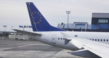 An aircraft at an airport. On the tail is the European flag.