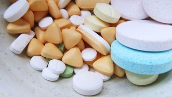 Food supplements: colourful pills on a table.