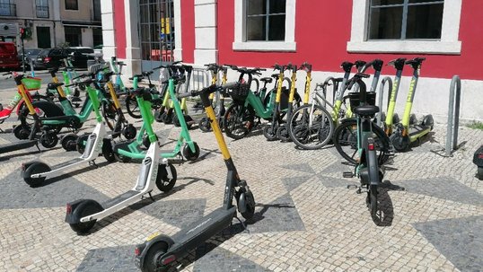 Geparkte E-Scooter und Fahrräder in Lissabon