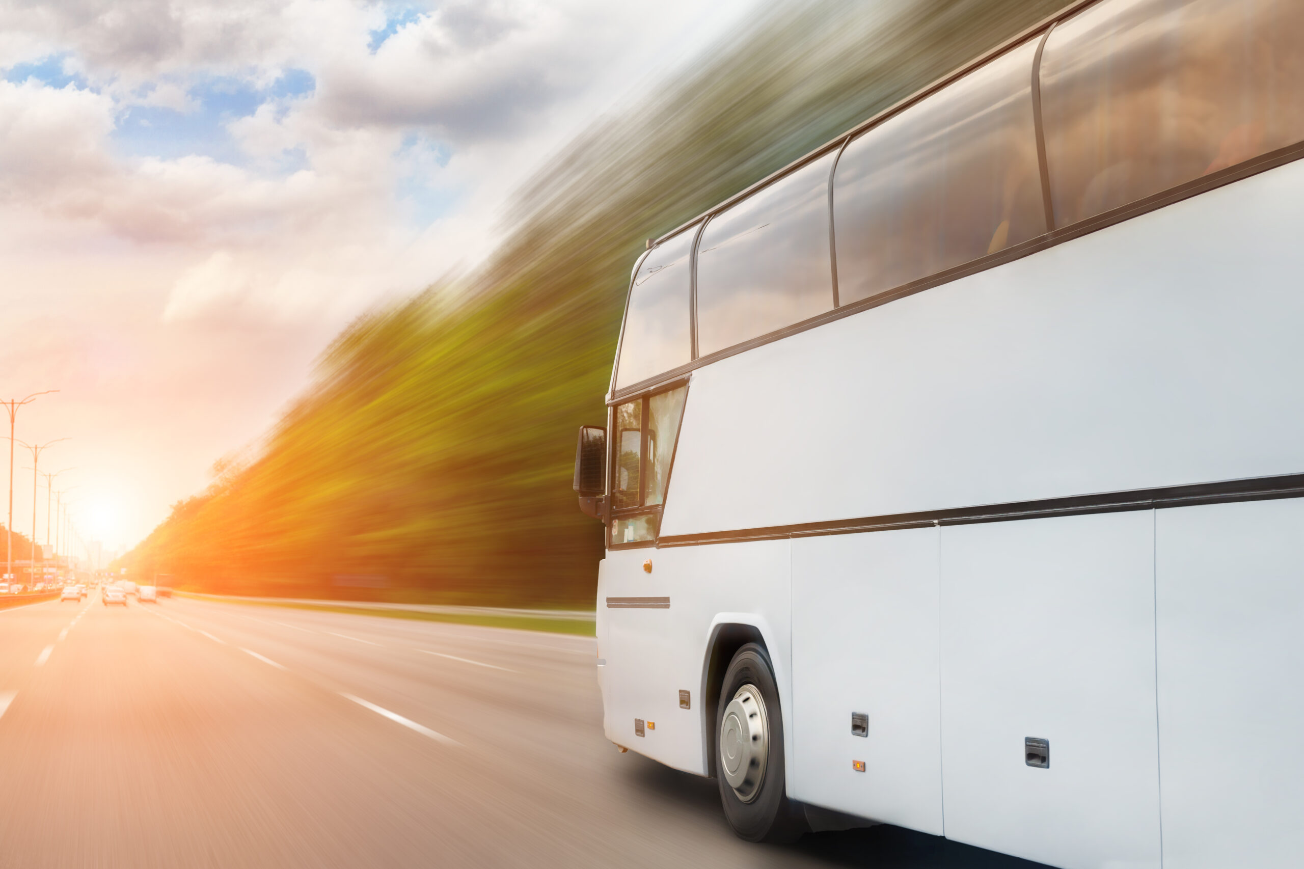 Ein komfortabler Reisebus fährt an einem hellen Sonnentag über die Autobahn.