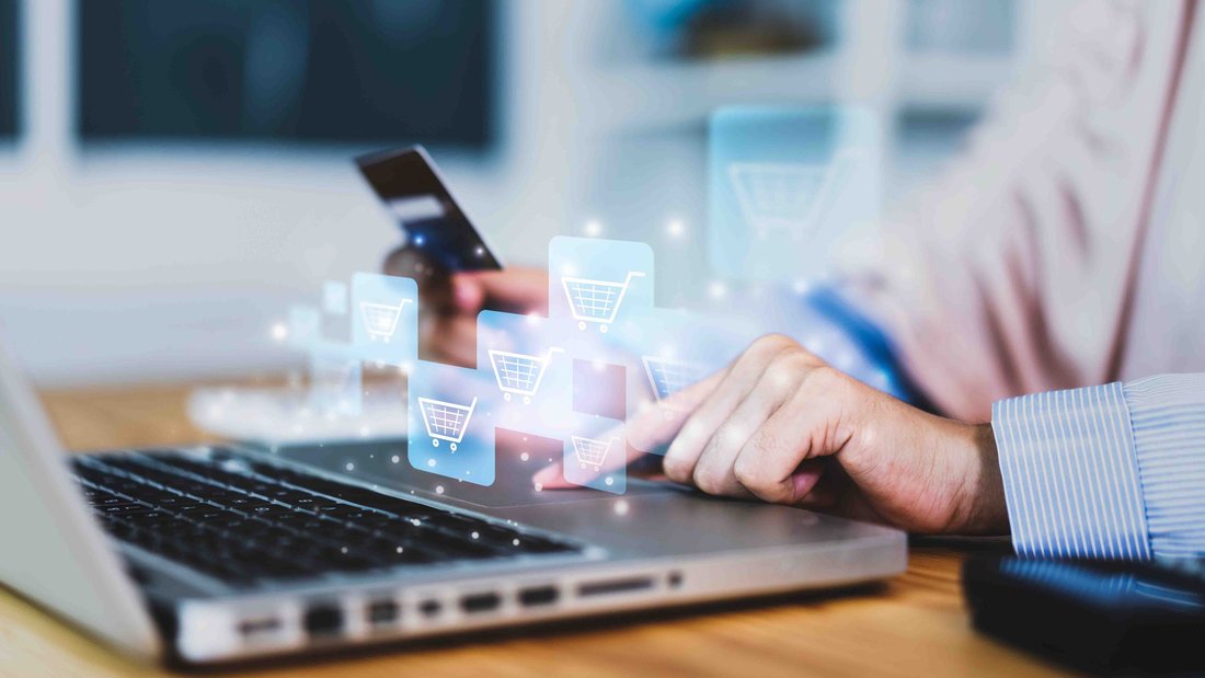 A man sitting in front of a laptop with a bank card