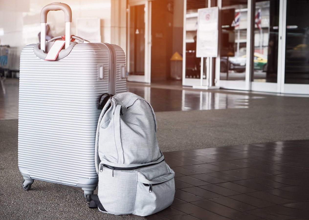 Ein Koffer und ein Rucksack stehen am Flughafen