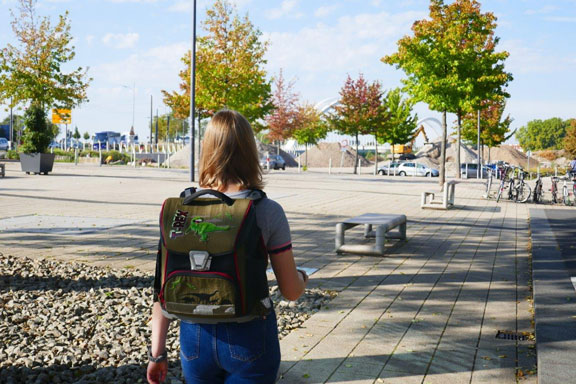 A woman with a backpack approaches the border of Germany.