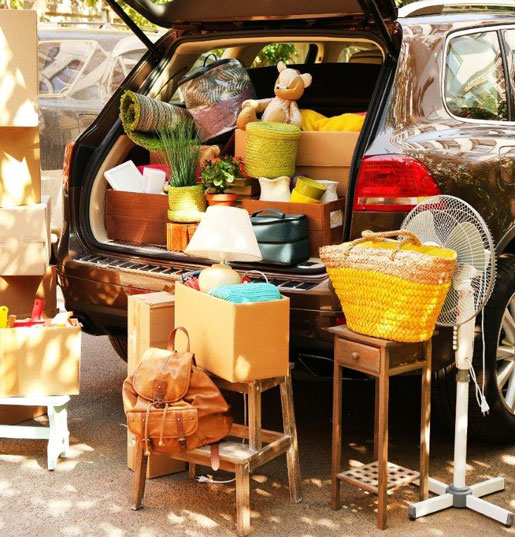 The image shows a car trunk ready for moving furniture. It illustrates an article on moving to Germany.