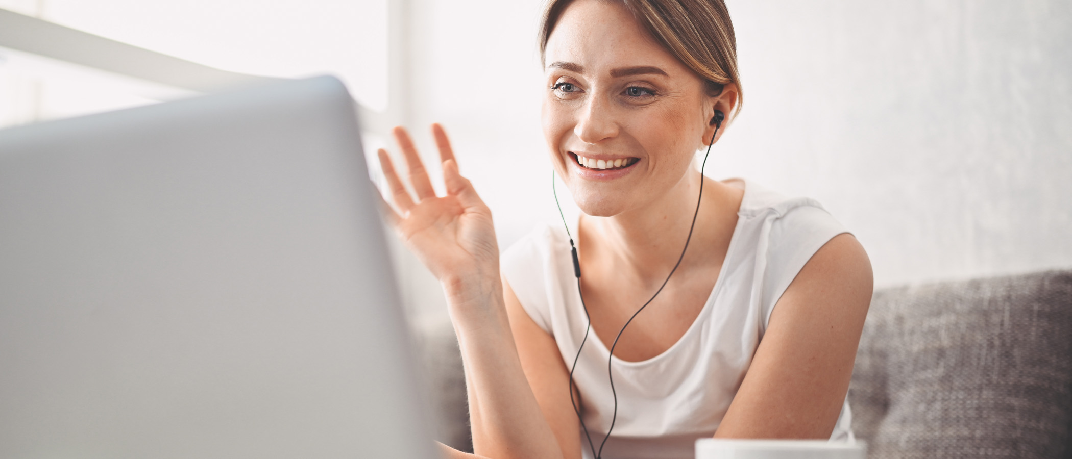 Eine Frau sitzt vor ihrem Bildschirm und chattet mit jemandem.