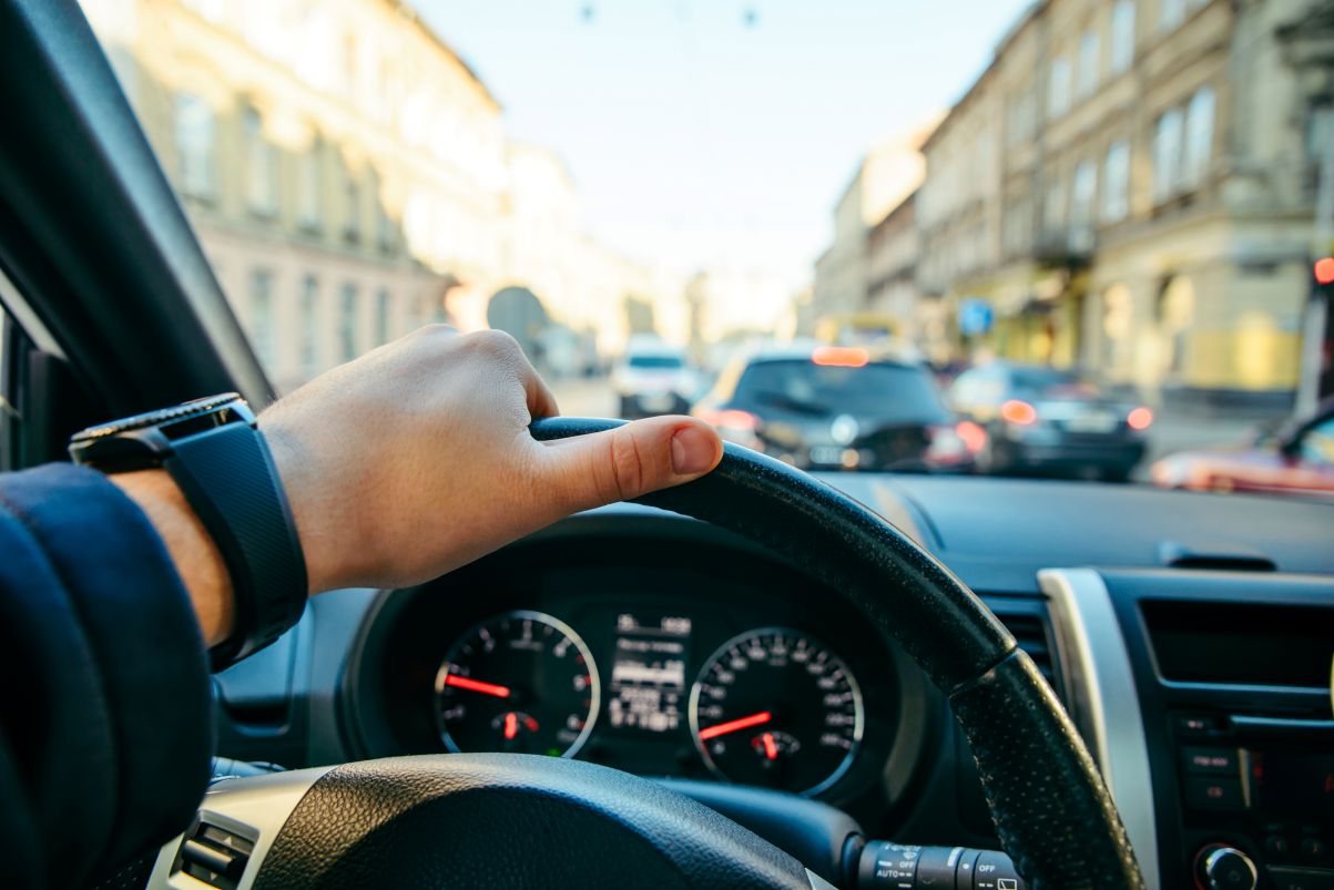 Person driving a car in heavy city traffic.