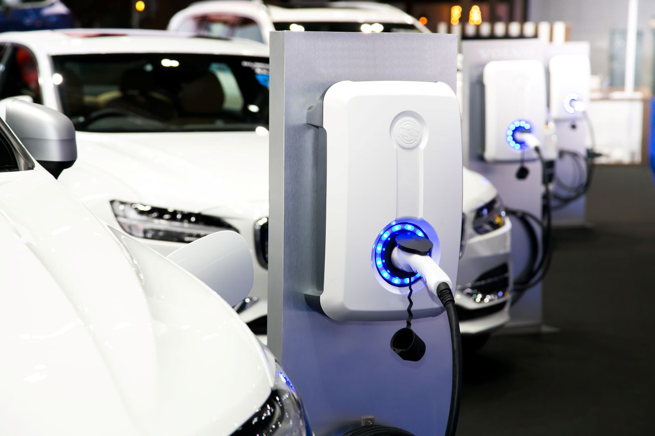 White electric cars plugged into charging stations.