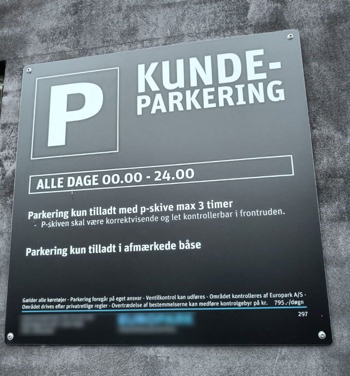 A sign displaying the terms and conditions in a supermarket car park in Denmark.