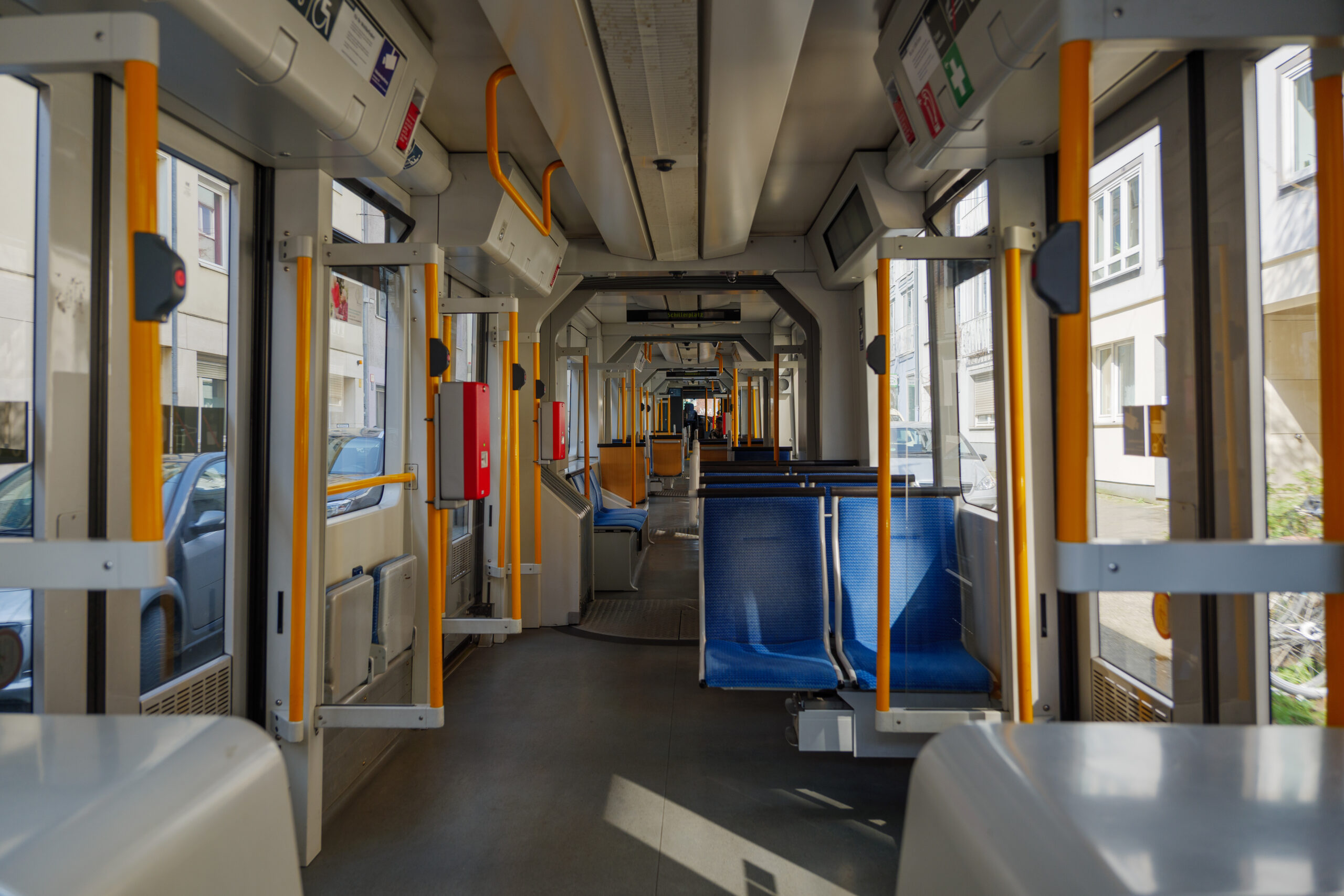 Interior view of a corridor inside a tram with blue fabric seats