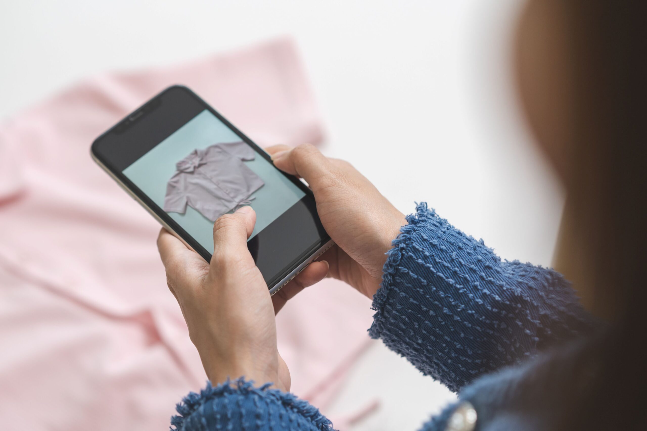 Eine Frau fotografiert ein Kleidungsstück.