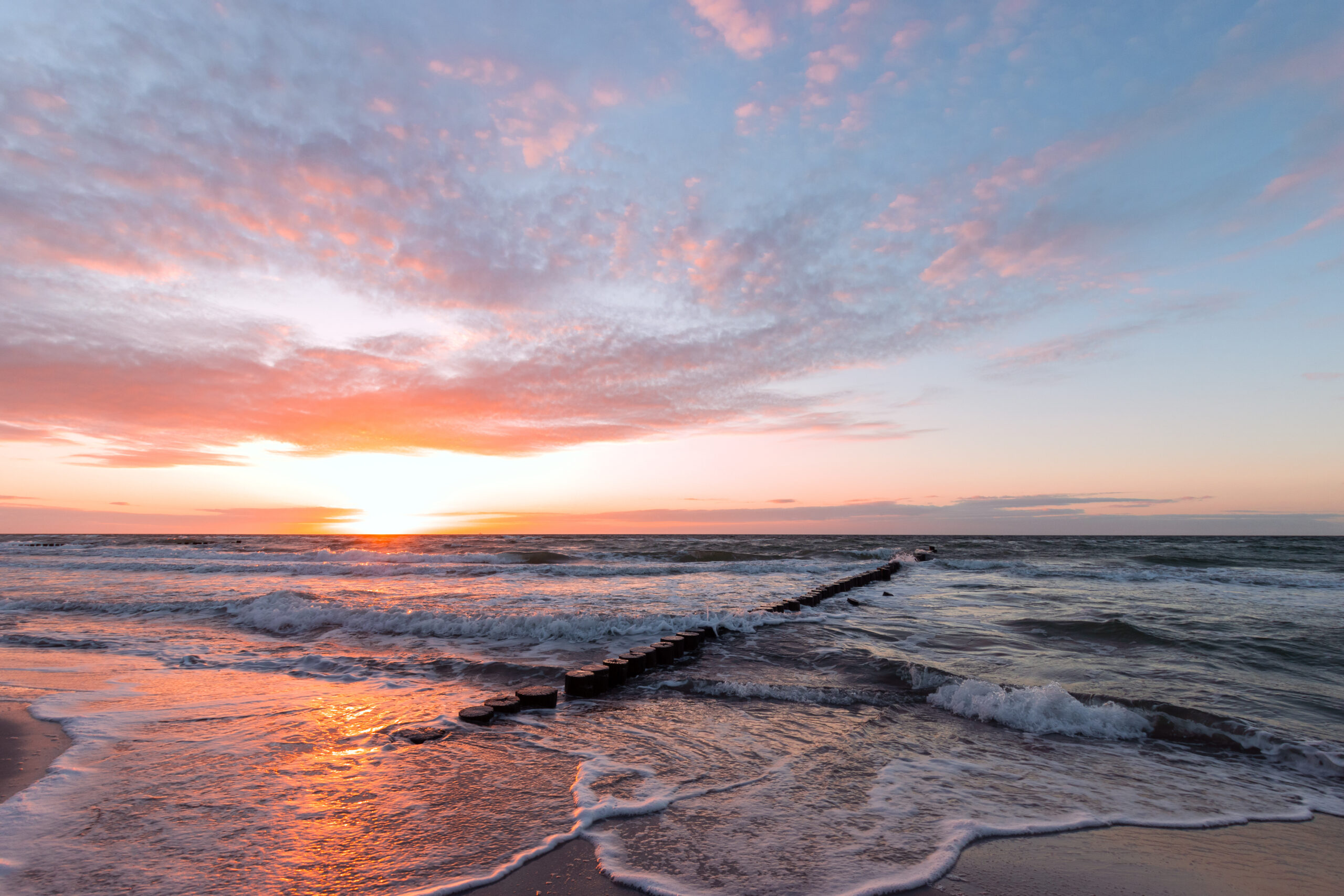 Strand und brechende Wellen beim Sonnenuntergang