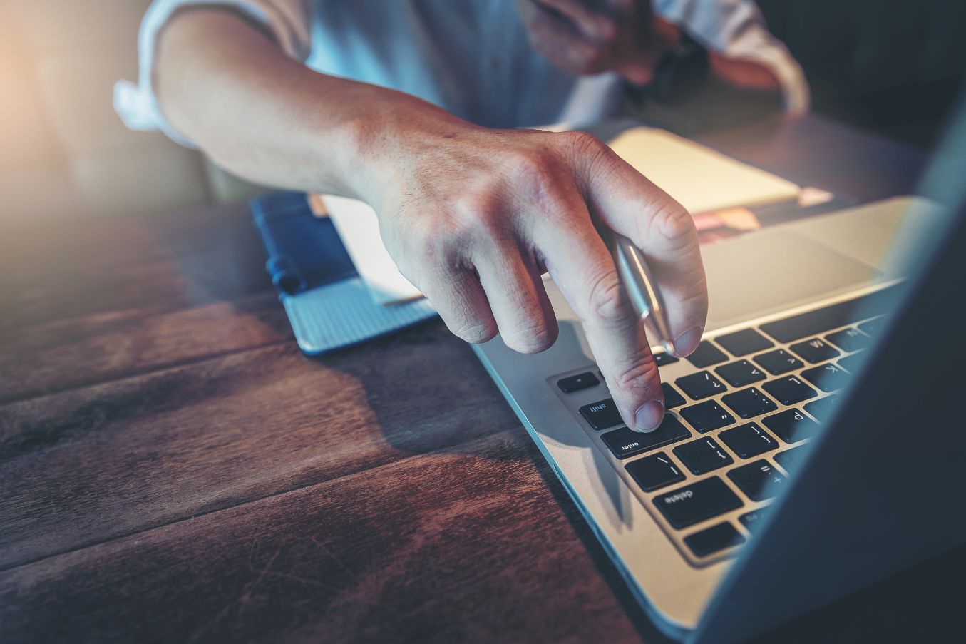 Ein Mann tippt mit dem Finger auf die Tastatur.