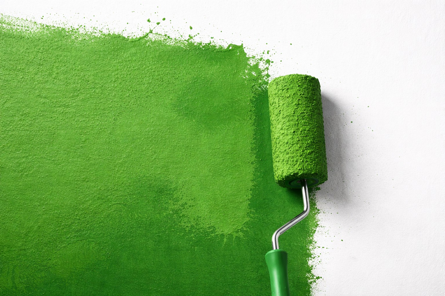 Grüner Farbroller streicht eine weiße Fläche als Symbolbild für Greenwashing im Tourismus und irreführende Nachhaltigkeitsversprechen.