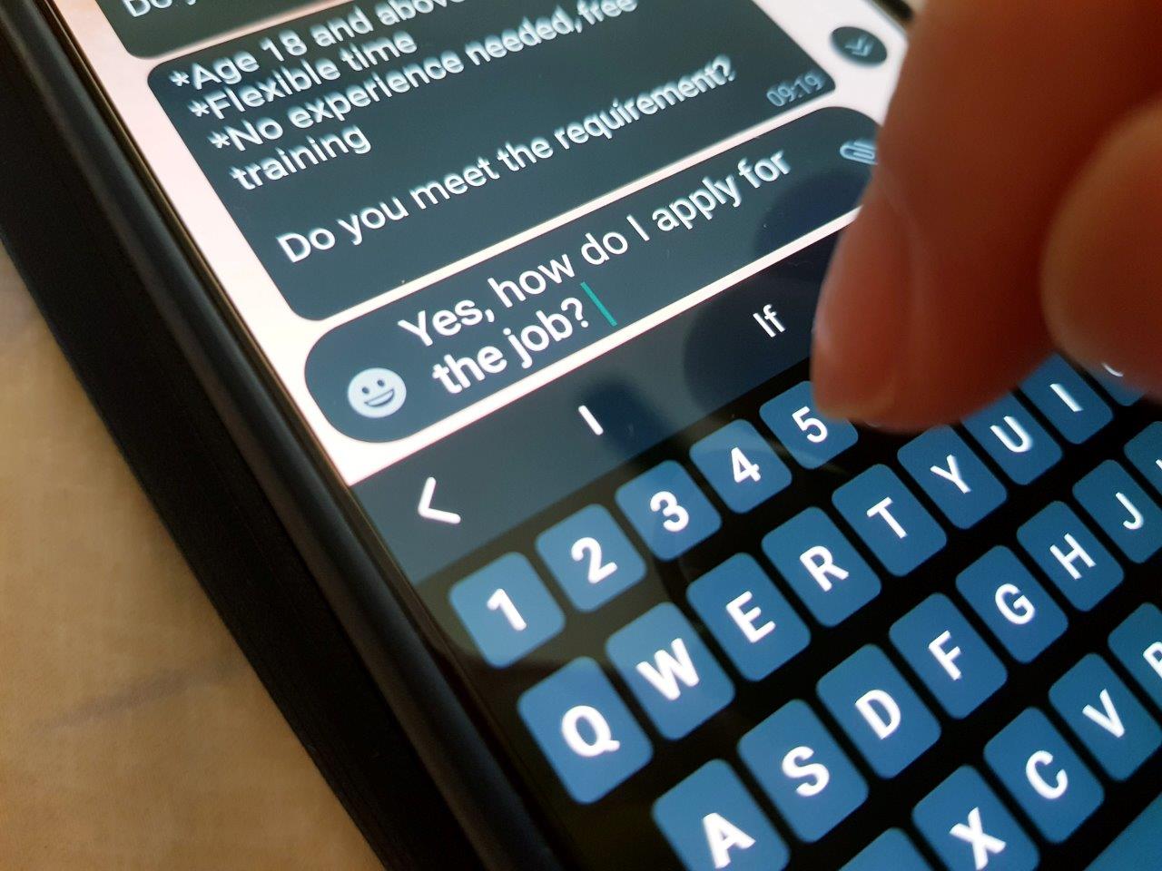 A person enters their details into a chat on a job portal via smartphone.
