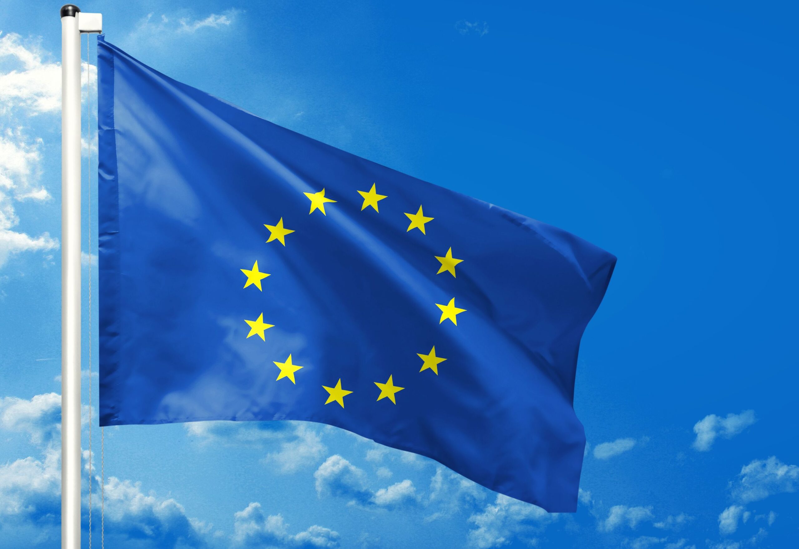Die Fahne der Europäischen Union weht vor strahlend blauem Himmel.