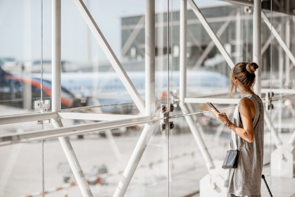 Eine Frau steht im Flughafenterminal und wartet auf ihren Flug.