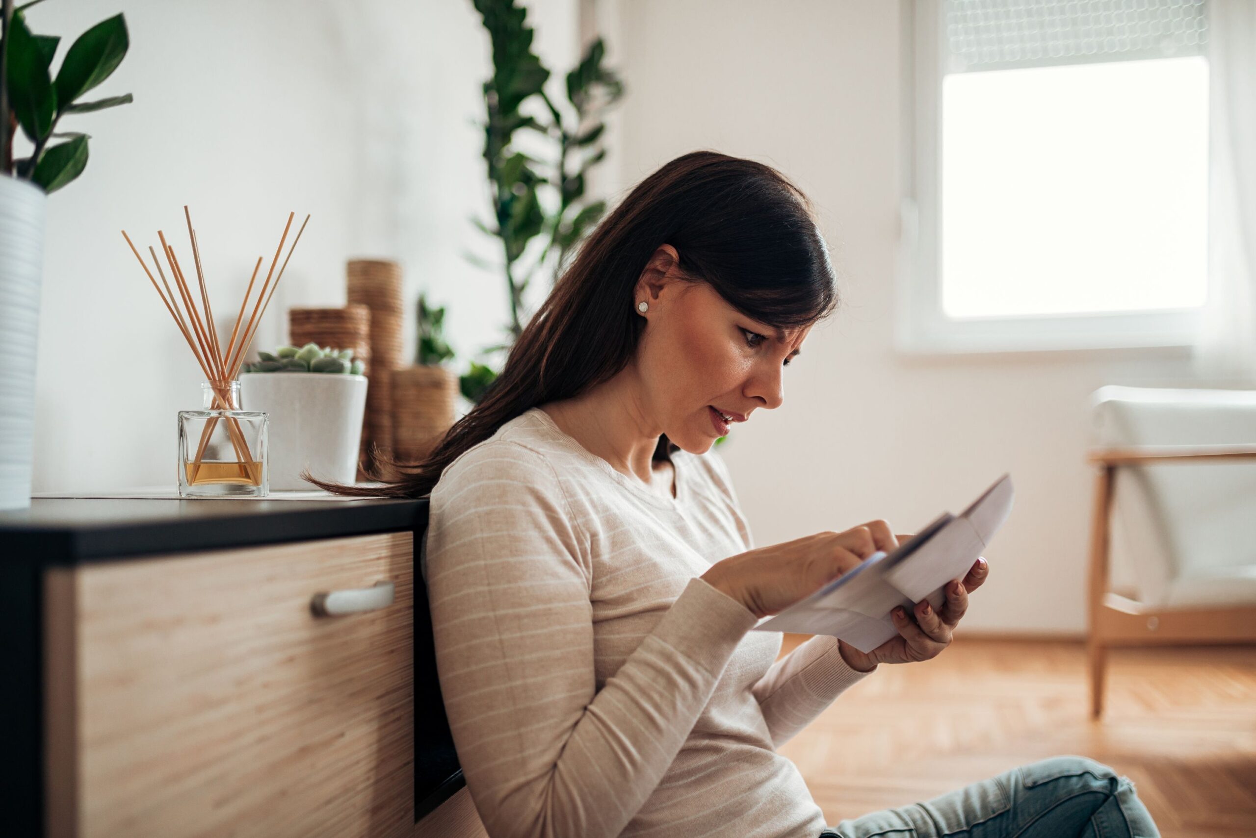 A woman is reading a debt collection letter.