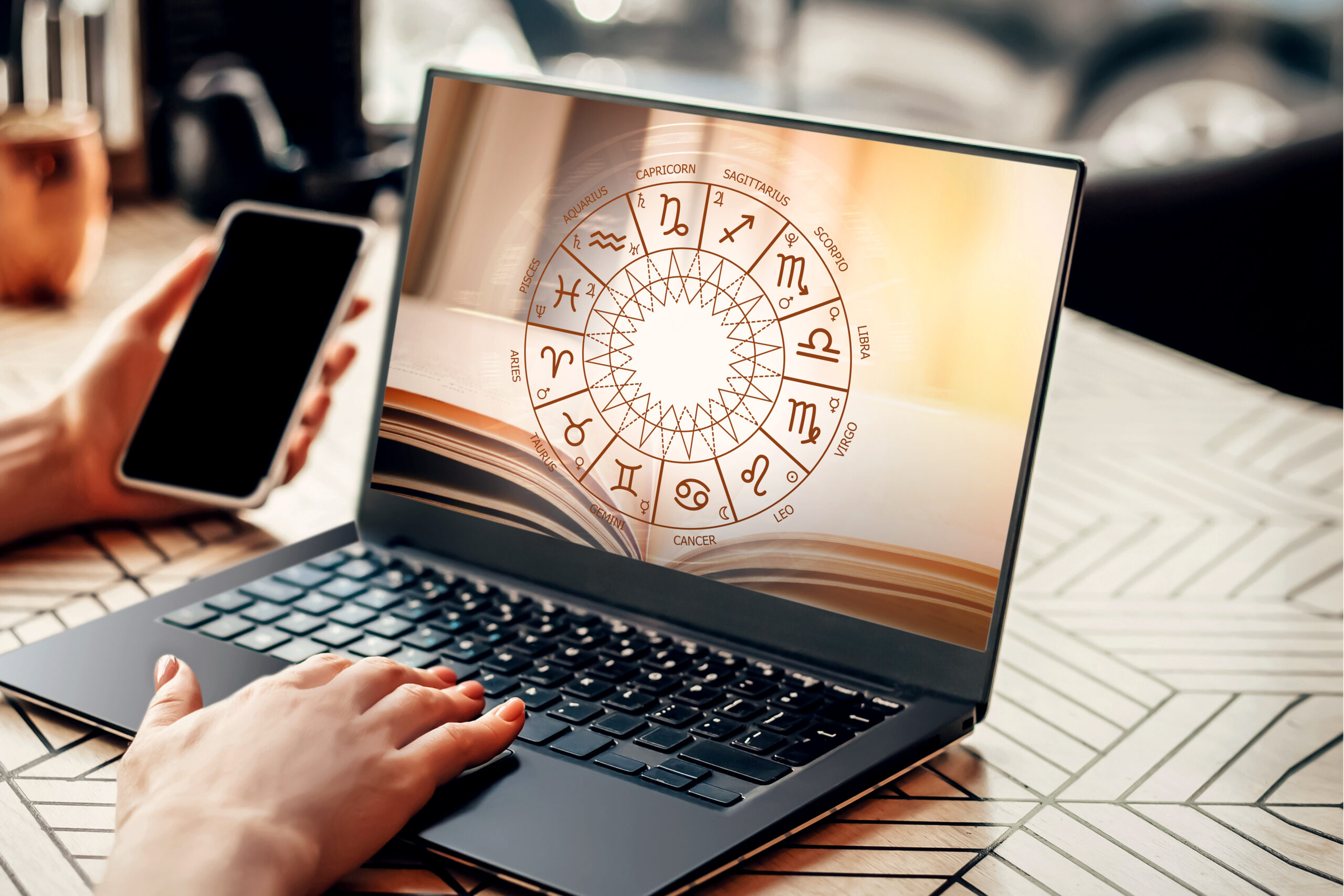 Jemand liest ein Online-Horoskop auf dem Laptop.