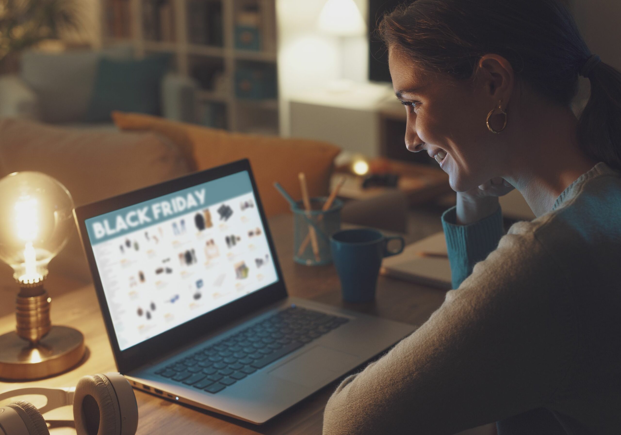 Eine Frau schaut sich die Black-Friday-Angebote am Laptop im Internet an.