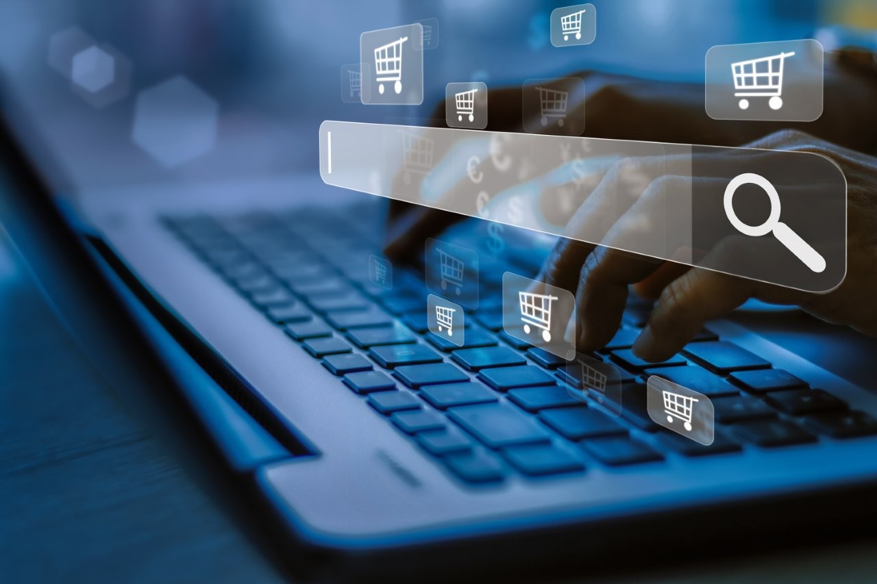 Person am Laptop. Symbole für Suchmaschine und Online-Shopping.
