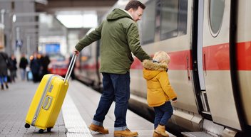 Ein Vater steigt mit seinem Sohn in einen ICE der Deutschen Bahn.