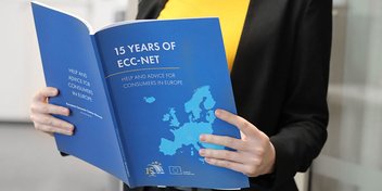 Eine Person hält den Jubiläumsreport des ECC-Net in ihren Händen.