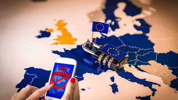 Frau hält Handy, im Hintergrund eine Europakarte