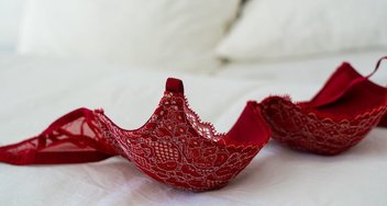 Red bra on a bed.