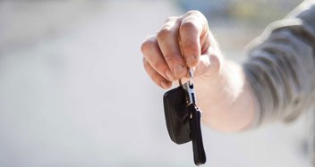 A person is holding a car key.