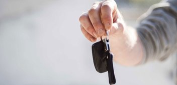 Eine Person hält einen Autoschlüssel in der Hand.
