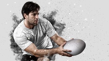 Das Foto zeigt einen stilisierten Rugby-Spieler im weißen Trikot, der einen Ball empfängt. Das Bild illustriert einen Artikel zur Rugby WM 2023 in Frankreich.